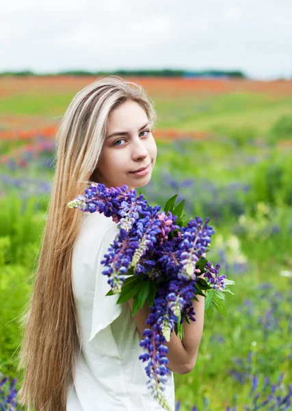 Menina com buquê de flores lupinas — Fotografia de Stock