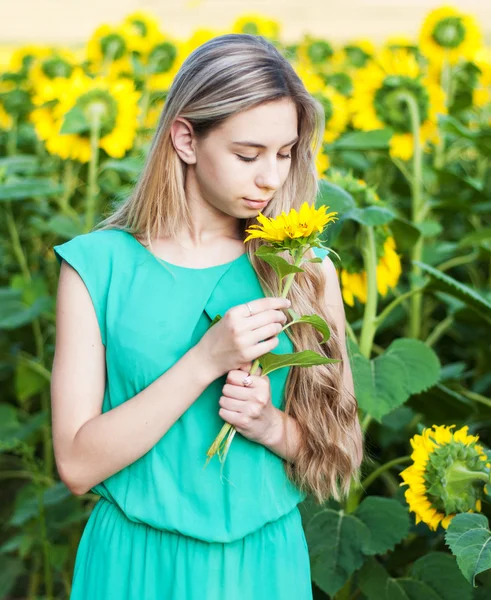 Flicka på fältet av solrosor — Stockfoto