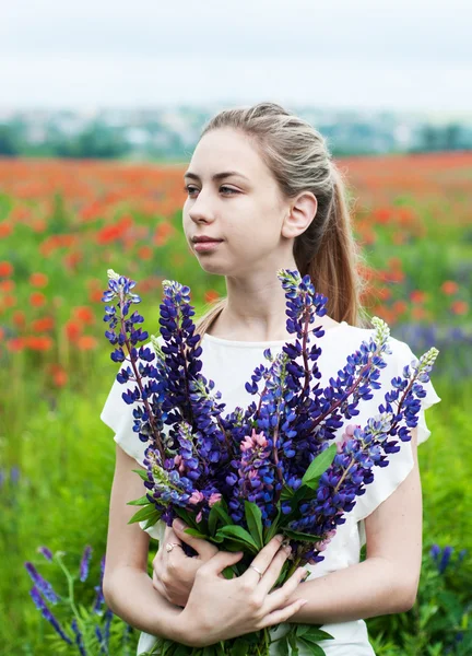 Menina com buquê de flores lupinas — Fotografia de Stock