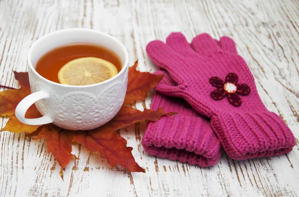 Tasse heißen Tee mit Zitrone und Handschuhen — Stockfoto