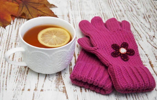Taza de té caliente con limón y guantes —  Fotos de Stock