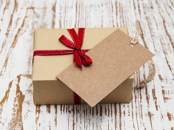 Vintage gift box package with blank tag — стоковое фото