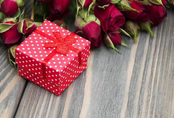 Красные розы и подарочная коробка — стоковое фото