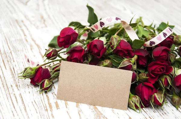 Rosa vermelha e cartão de saudação — Fotografia de Stock