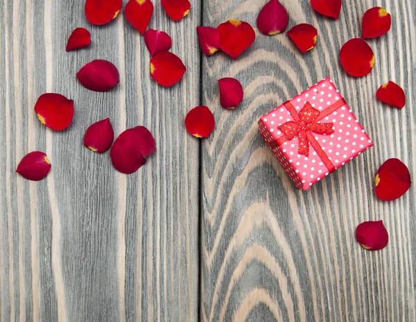 Geschenk box en rozen bloemblaadjes — Stockfoto