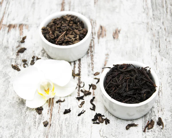 Té negro y verde con flor de orquídea — Foto de Stock