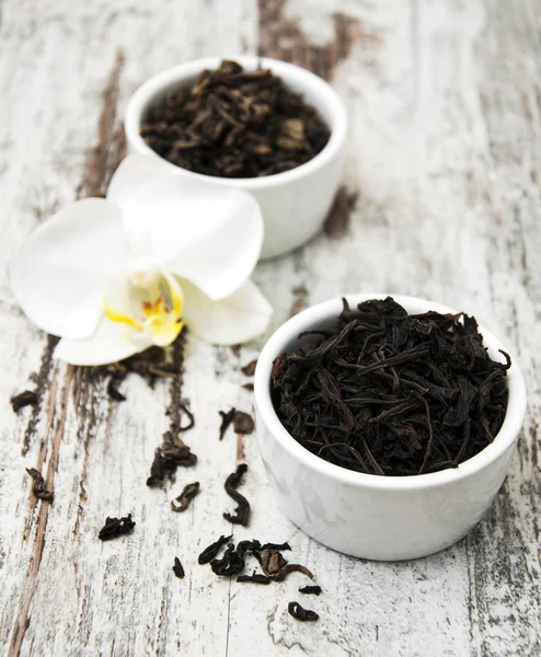 Té negro y verde con flor de orquídea — Foto de Stock