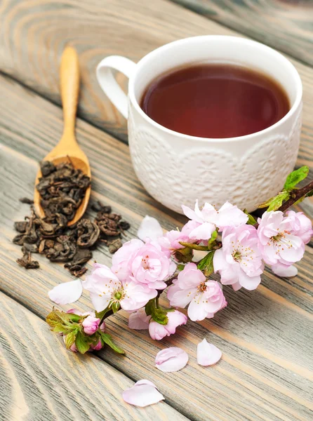 Xícara de chá e flor de sakura — Fotografia de Stock