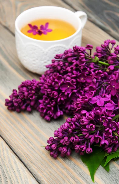 Cup of tea and lilac flowers — Stock Photo, Image