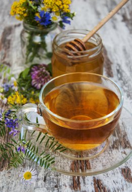 Fincan çay, bal ve çiçekler