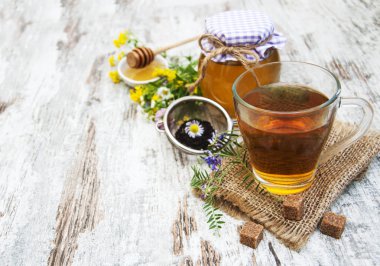 Fincan çay, bal ve çiçekler