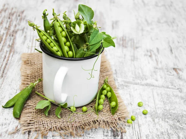 Metall kopp med färska ärter — Stockfoto