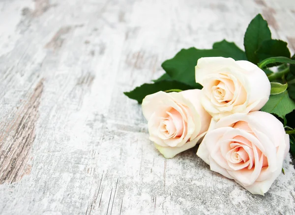 Rosas sobre una mesa de madera — Foto de Stock