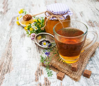Fincan çay, bal ve çiçekler