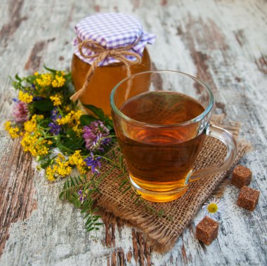 Fincan çay, bal ve çiçekler