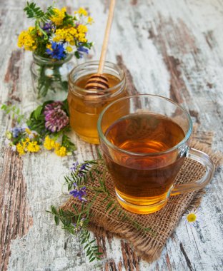 Fincan çay, bal ve çiçekler