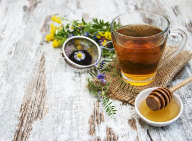 Fincan çay, bal ve çiçekler