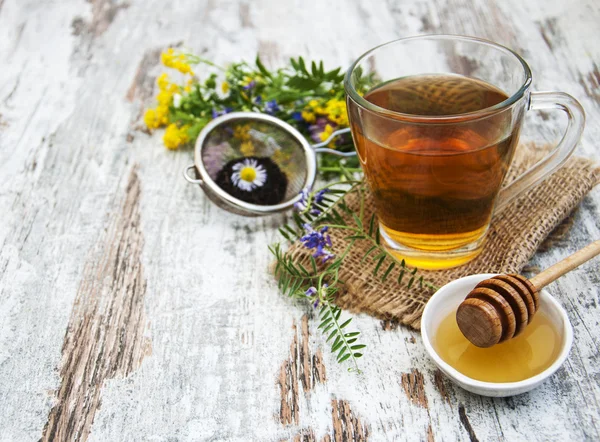 Fincan çay, bal ve çiçekler