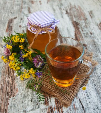 Fincan çay, bal ve çiçekler