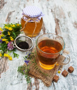 Fincan çay, bal ve çiçekler