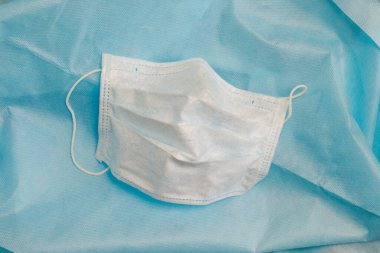 Mavi dokumasız kumaş üzerinde tek kullanımlık tıbbi maske