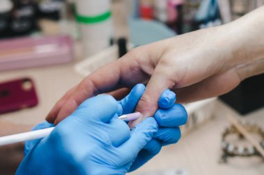 Bir manikürcü müşterinin derisini yakın plan çeker.