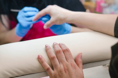 Manikür ustasının arka planındaki kadın eli, yakın plan.