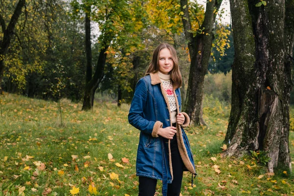 Piękna Dziewczyna Długimi Włosami Niebieskim Płaszczu Jeansowym Jesiennym Parku — Zdjęcie stockowe