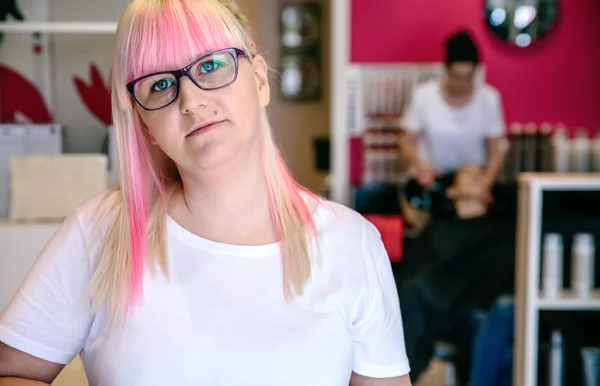 Peluquería mujer de pie en el pelo y salón de belleza — Foto de Stock