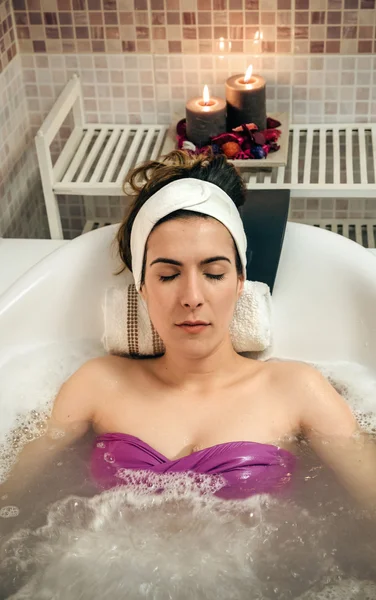 Mulher deitada na banheira fazendo tratamento de hidroterapia — Fotografia de Stock