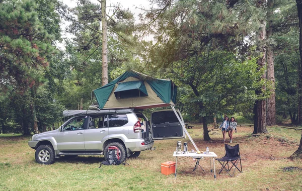 Camping table and off road vehicle in campsite — Stock Photo, Image