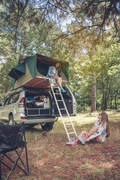 Donna in tenda sopra l'auto e altri scarponi da trekking — Foto Stock