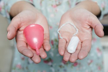 Tampon ve adet Kupası onun elinde tutan kadın