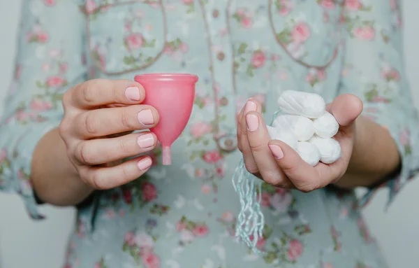 Frau hält Tampons und Menstruationstasse in Händen — Stockfoto