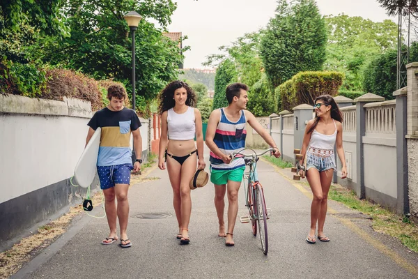Happy young people walking along road in summer day — Stock Photo, Image