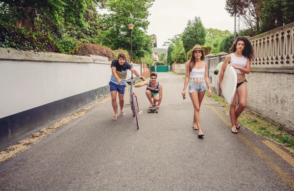 Happy young people having fun with skateboard and bicycle — Stock Photo, Image