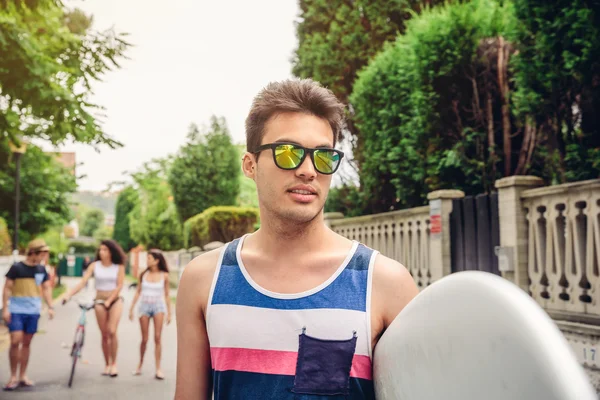 Close up of young man with sunglasses holding surfboard — Stock Photo, Image