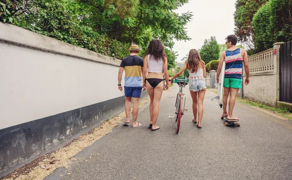 Back view of young people walking along road — Stock Photo, Image