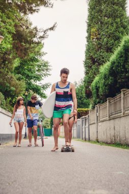 Paten üzerinde sürme ve surfboard holding genç adam