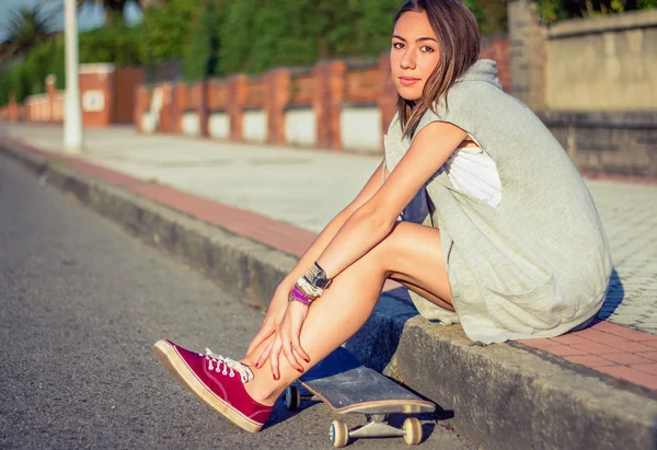 Young girl with skateboard sitting outdoors on summer — Stock Photo, Image