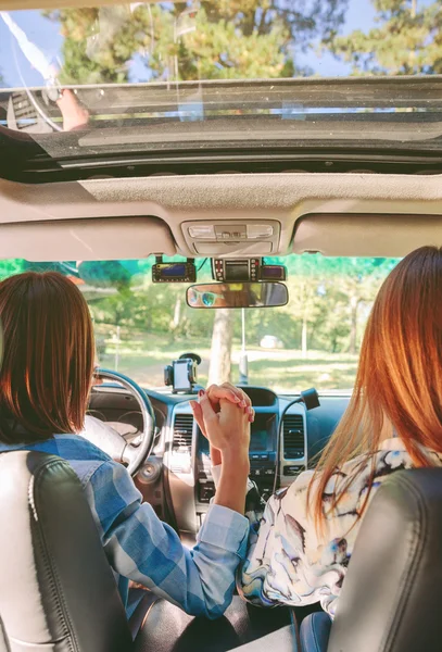 Gelukkig vrouwen hand in hand binnenkant auto — Stockfoto