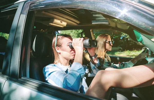 쌍안경과 운전 하는 친구를 통해 보고 하는 여자 — 스톡 사진
