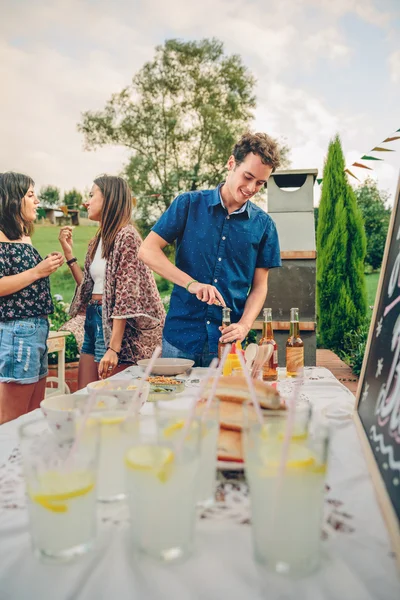 Hombre abriendo la botella de cerveza en verano barbacoa — Foto de Stock