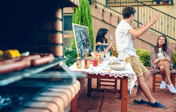 若者が屋外の話と炉の料理食事 — ストック写真