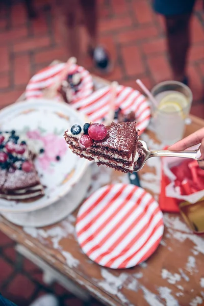 Donna con pezzo di torta in una festa estiva — Foto Stock