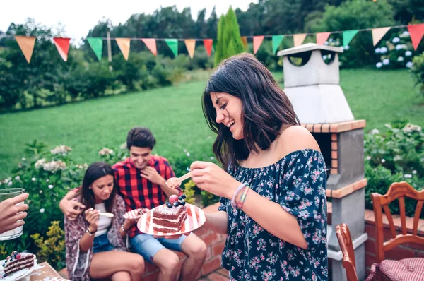 Mujer comiendo pedazo de pastel en la fiesta de verano — Foto de Stock