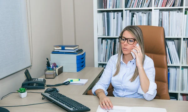 事務所に電話で話している金髪の実業家 — ストック写真