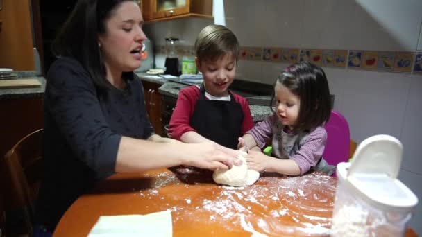 Madre e hijos se divierten amasando masa en casa — Vídeos de Stock