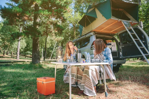 Frau spielt auf Campingplatz mit Freundin Mundharmonika — Stockfoto