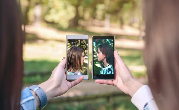 Mulheres mostrando smartphones com vista lateral retratos fotos — Fotografia de Stock